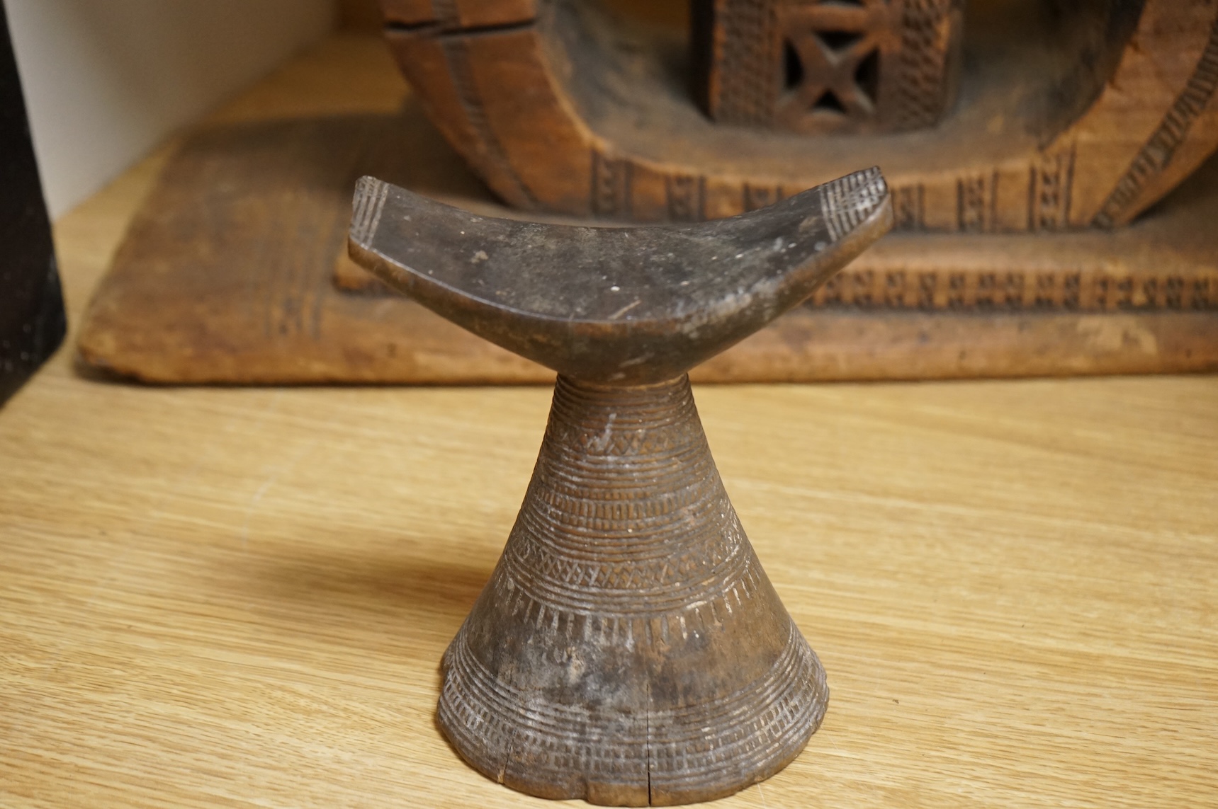 An Ashanti carved wood stool together with a similar headrest, tallest 41cm